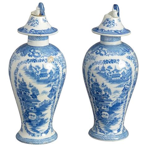 Two Blue And White Vases Sitting Next To Each Other