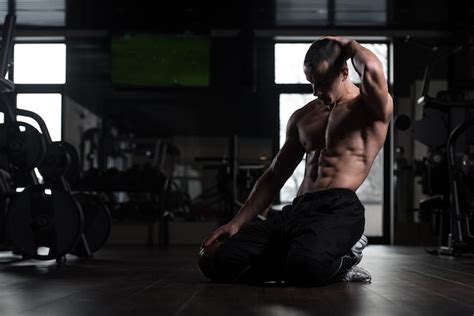 premium photo muscular man flexing muscles in gym