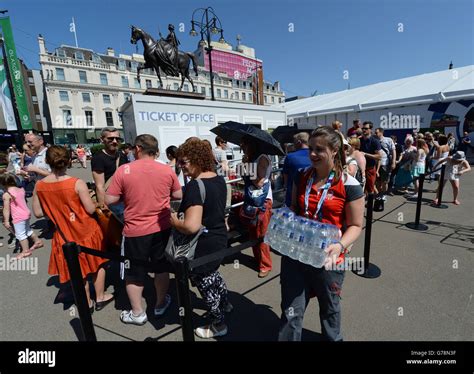 Free Bottled Water Is Handed Out As Hundreds Wait In Soaring Temperatures To Buy Tickets At The