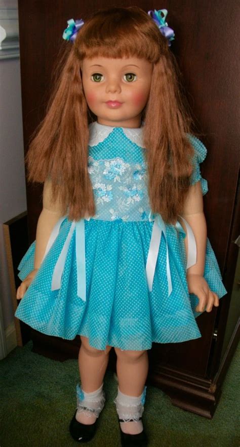 The Doll Is Wearing A Blue Dress And Black Shoes