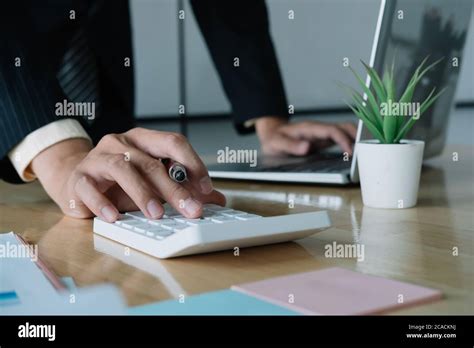 Close Up Of Businessman Or Accountant Hand Holding Pen Working On