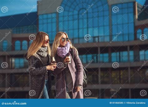 Two Beautiful Young Women Talking While Walking The Street After