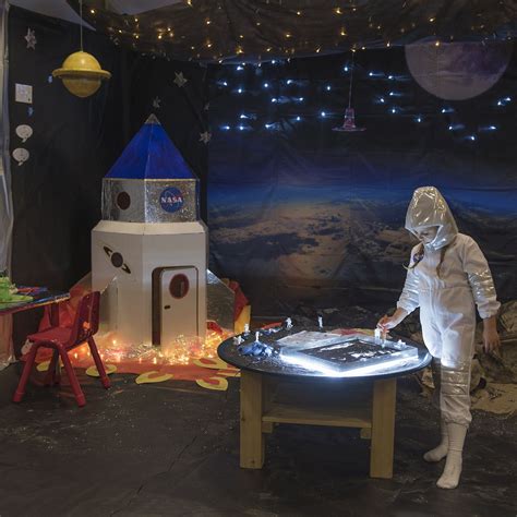 A Person In A Space Suit Standing Next To A Table With An Object On It