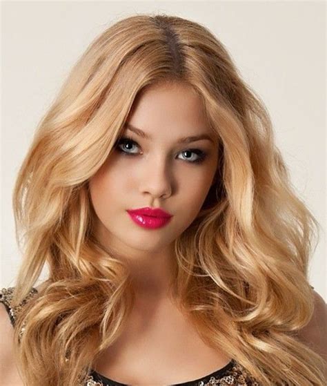 A Woman With Long Blonde Hair Wearing A Black Dress And Red Lipstick On Her Lips