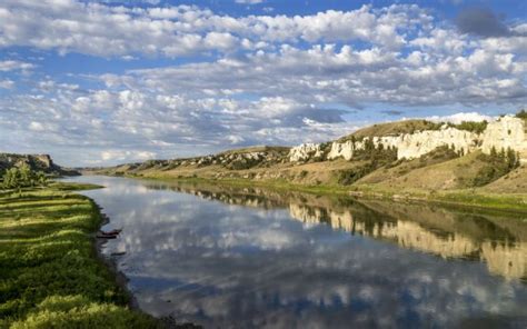 River Between Green Grass Field White Covered Mountains Reflection On