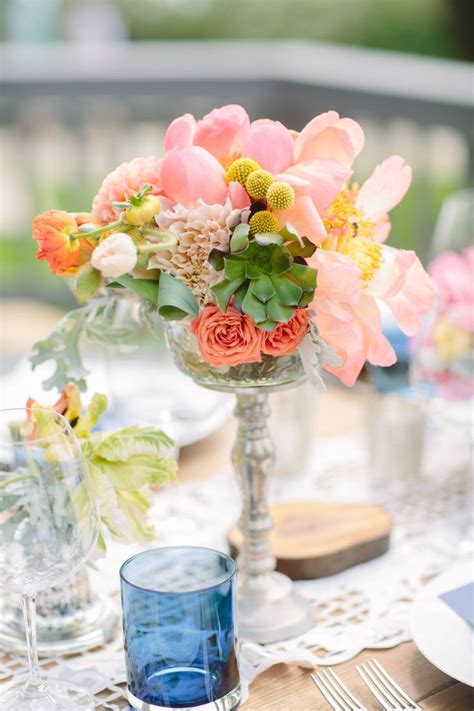 A Vase Filled With Flowers Sitting On Top Of A Table Next To Glasses