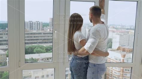 Babe Happy Couple Embracing Standing Near Window And Enjoying View