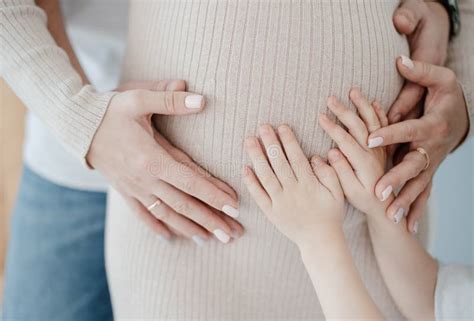 Hands Of Mom Dad And Son On Mothers Pregnant Belly Stock Photo