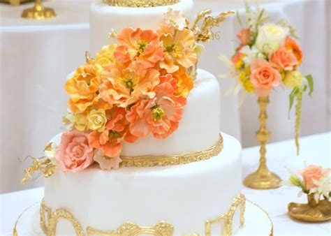 White And Gold Wedding Cake With Bright Peach Orange