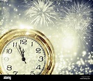 New Year's at midnight - Old clock with fireworks and holiday lights ...