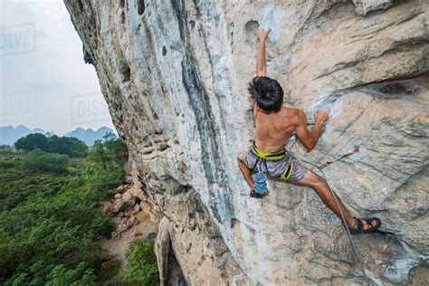 Male Climber Climbing At White Mountain A Limestone Cliff In Yangshuo