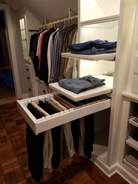 An Open Closet With Clothes Hanging On Shelves