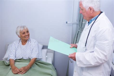 Doctor Interacting With Senior Patient In Ward Stock Image Image Of