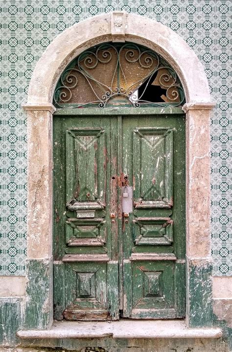 An Old Green Door With Ornate Iron Work On It