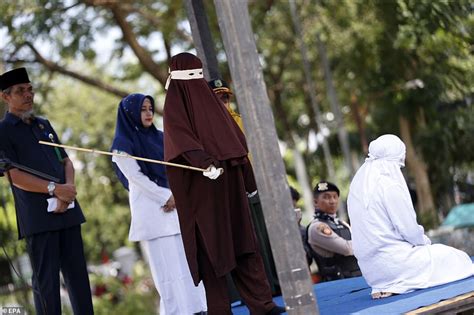 indonesian woman is caned in public for having sex outside marriage photos