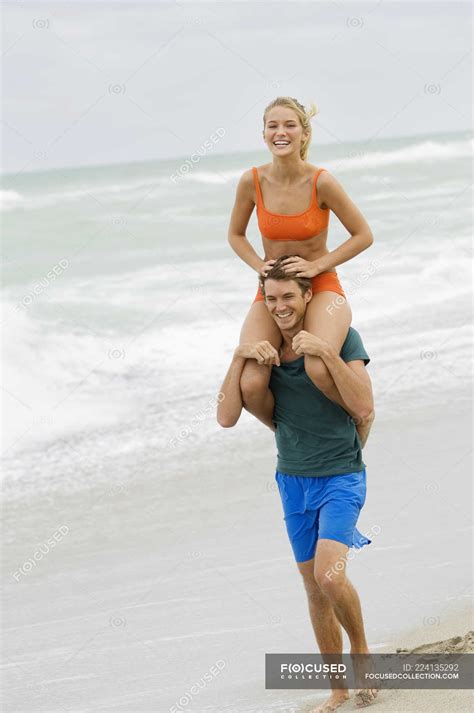 Hombre Cargando Mujer En Hombros En La Playa Traje De Nataci N Ocio