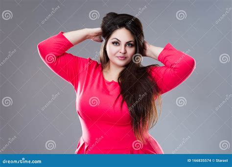 happy plus size model in red dress fat woman with long hair on gray
