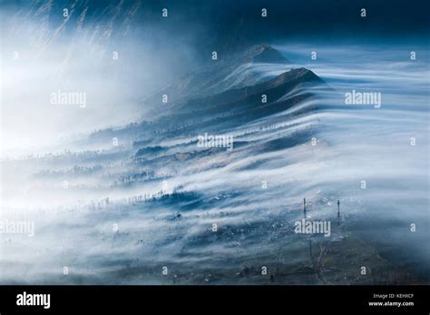 Mist Flowing Over Cemoro Lawang And Into Crater Gunung Bromo Or Mount