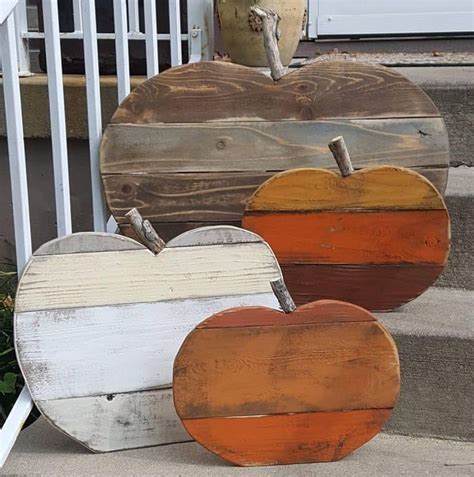 Three Wooden Heart Shaped Pumpkins Sitting On The Steps