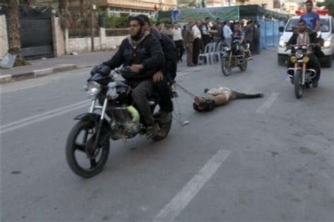 צילום AP Hamas members drag body of suspected Israeli collaborator