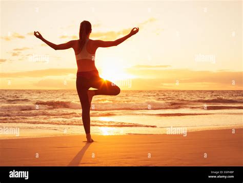 Silueta De Mujer Joven Practicando Yoga En La Playa En El Atardecer