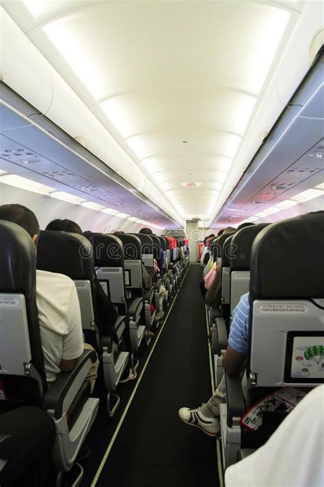 Inside Airplane Cabin Walkway Between Rows Of Passenger Seats In