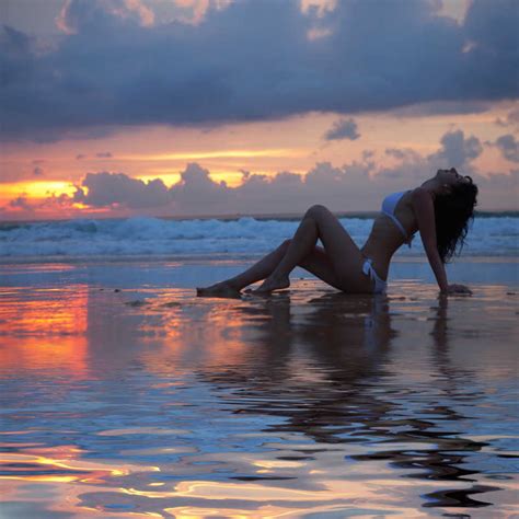 夕阳下的性感女人图片素材 夕阳下坐在海滩上的性感女人创意图片 格式 未来素材下载