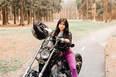 Premium Photo The Beautiful Brunette Riding A Motorcycle In The Park