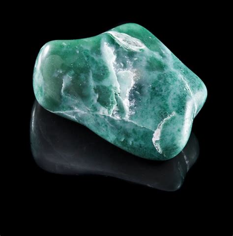 Jadeite Mineral Stone Close Up With Reflection On Black Surface