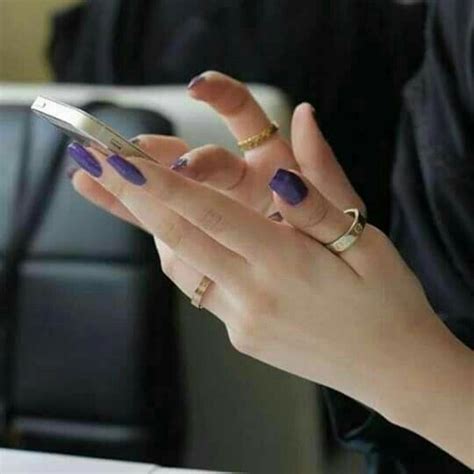 A Woman Is Holding Her Cell Phone In Her Hand
