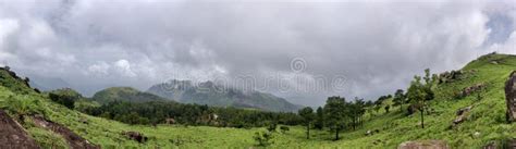 A Sceneic Veiw Of Meadow Filled With Grass Rocks And Trees On A