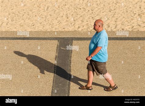 Fat Man Walking Along The Beach Stock Photo Alamy
