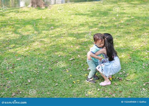 Asian Sister Carrying Her Little Brother In The Garden Outdoor Foto De Stock Imagem De Grama