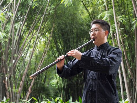One Chinese Man Playing Vertical Bamboo Flute In The Bamboo Wood By