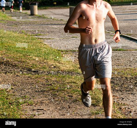 A Male Shirtless Runner Is Running On A Grass Path At Sunken Meadow State Park On A Summer
