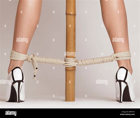 Sexy Woman Legs Tied With Bondage Ropes To A Bamboo Pole Stock Photo