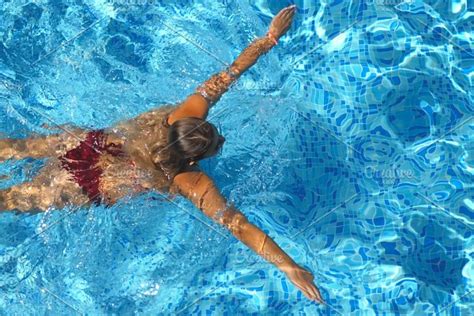 Unrecognizable Beautiful Girl In Red Bikini Floating Across The Pool Of