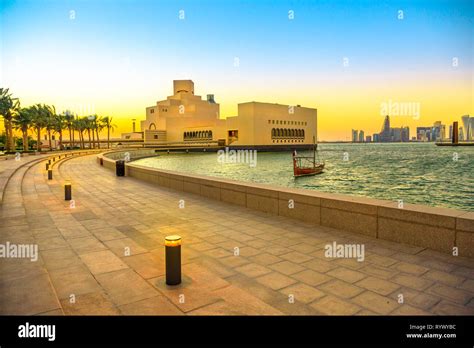 Seafront Walkway With Palm Trees Along Doha Bay With Dhow And