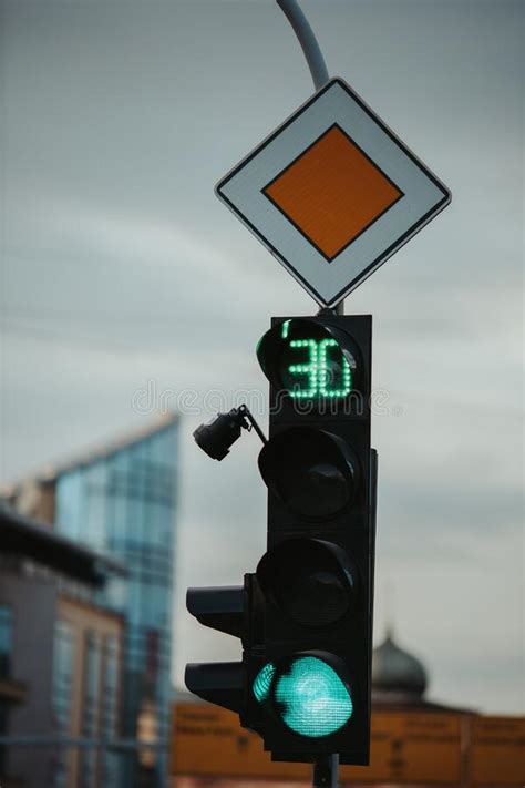 Closeup Of A Green Traffic Light For Cars And The Main Road Sign 30