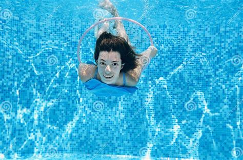 Child Swims In Swimming Pool Underwater Happy Active Teenager Girl