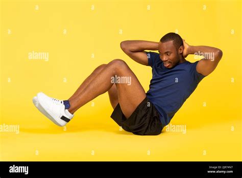 Black Fitness Guy Doing Sit Ups Exercise On Yellow Background Stock