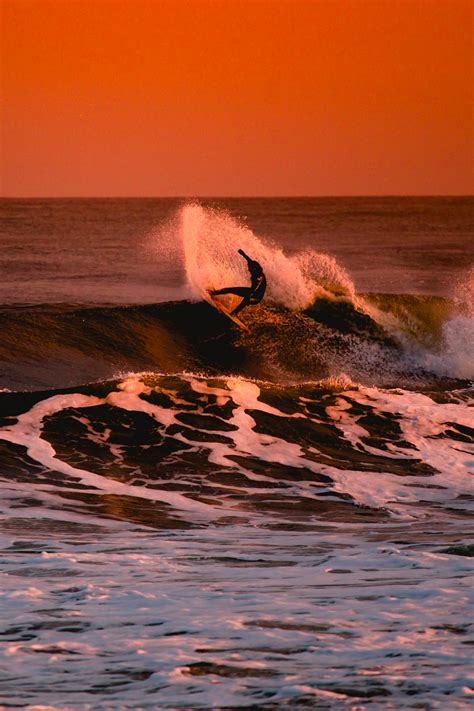 Person Surfing During Sunset Photo Free Surf Image On Unsplash