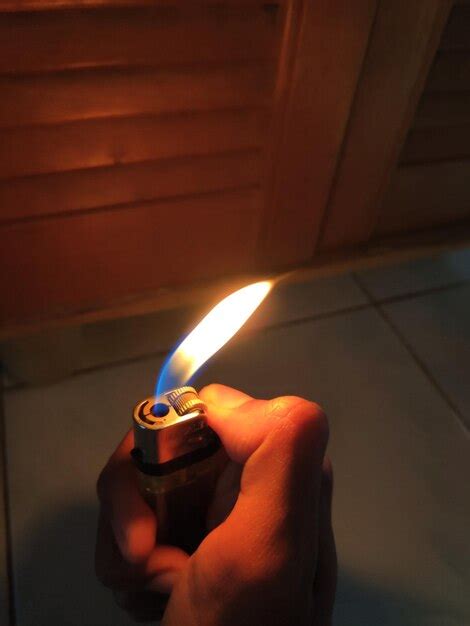 Premium Photo Close Up Of Hand Holding Lit Cigarette Lighter