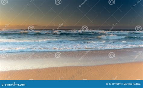 Clear Skies Waves Washing Up On The Beach Sunrise Seascape Stock Image