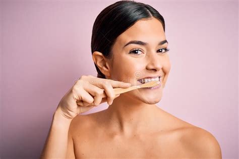 Young Beautiful Brunette Woman Brushing Her Teeth Using Tooth Brush And Oral Paste Cleaning