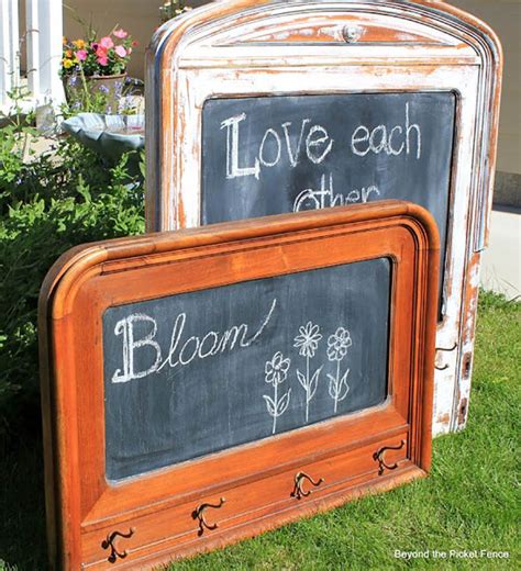 Two Chalkboards With Writing On Them Sitting In The Grass Next To Some