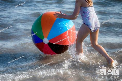 Girl Playing With A Colourful Beach Ball In The Sea Stock Photo