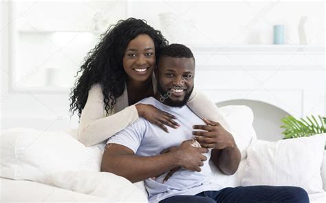 Happy black couple in love having romantic moments at home, woman tenderly touching her husband's head. Happy African American Couple Smiling And Posing To Camera ...