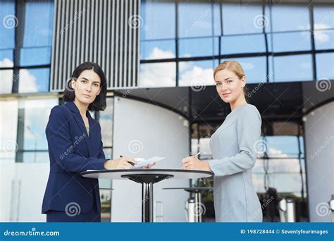 Two Successful Businesswomen Meeting At Table In Cafe Stock Photo