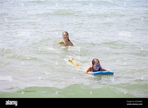 Two Girls Having Fun On The Beach With The Bodyboard And The Waves